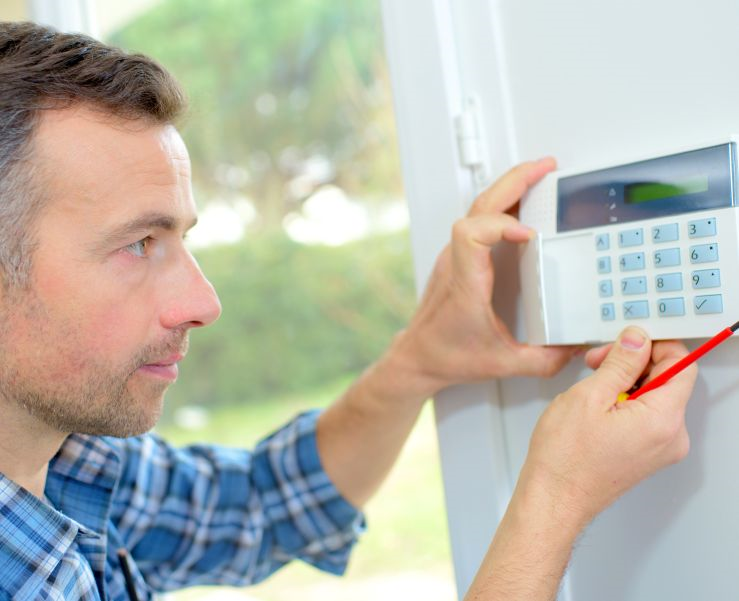 Man installing a burglar alarm.